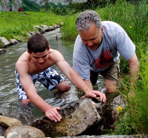 Children play outside when given a vision for how fun it can be. Children play outside image of Chris building a dam with his son Chris.