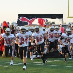 Brit Vernon leads the varsity team onto the field.