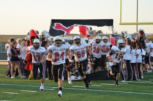 Brit Vernon leads the varsity team onto the field.